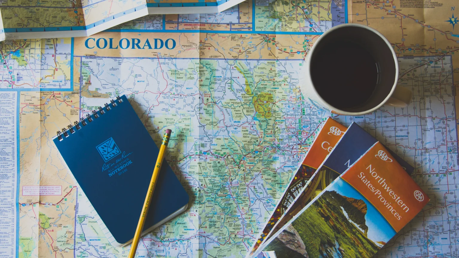 Mapa de viaje con libreta, café y folletos para planificar un itinerario