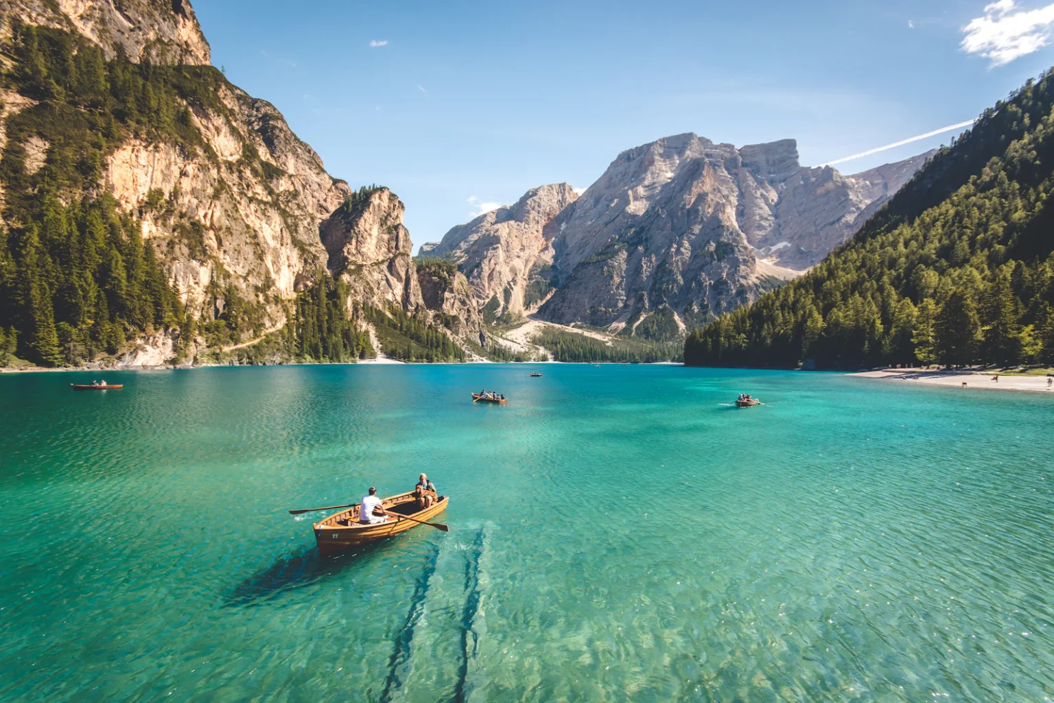 Lago entre montañas con botes de madera al amanecer